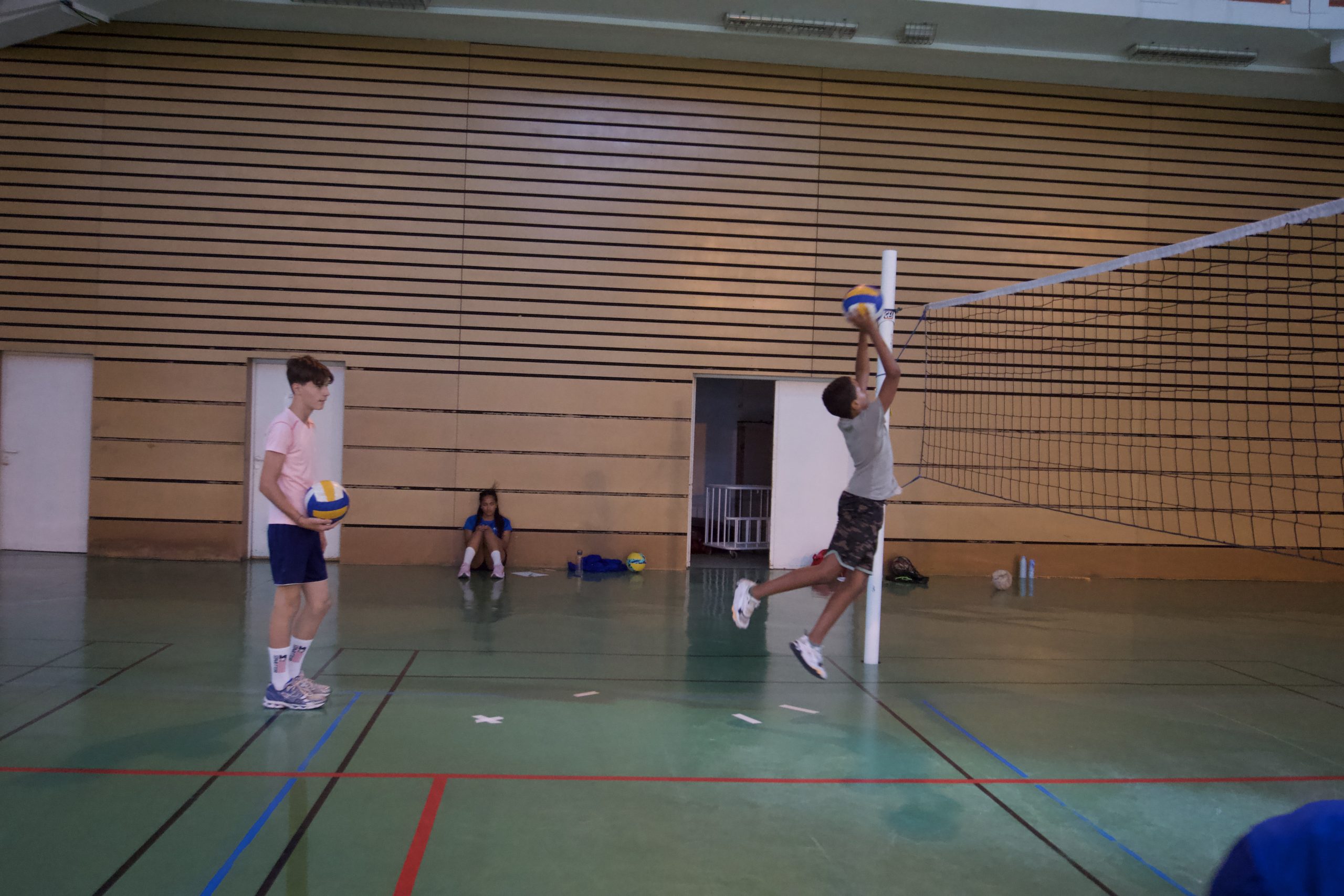 Entraînement de volley-ball en salle avec trois personnes.