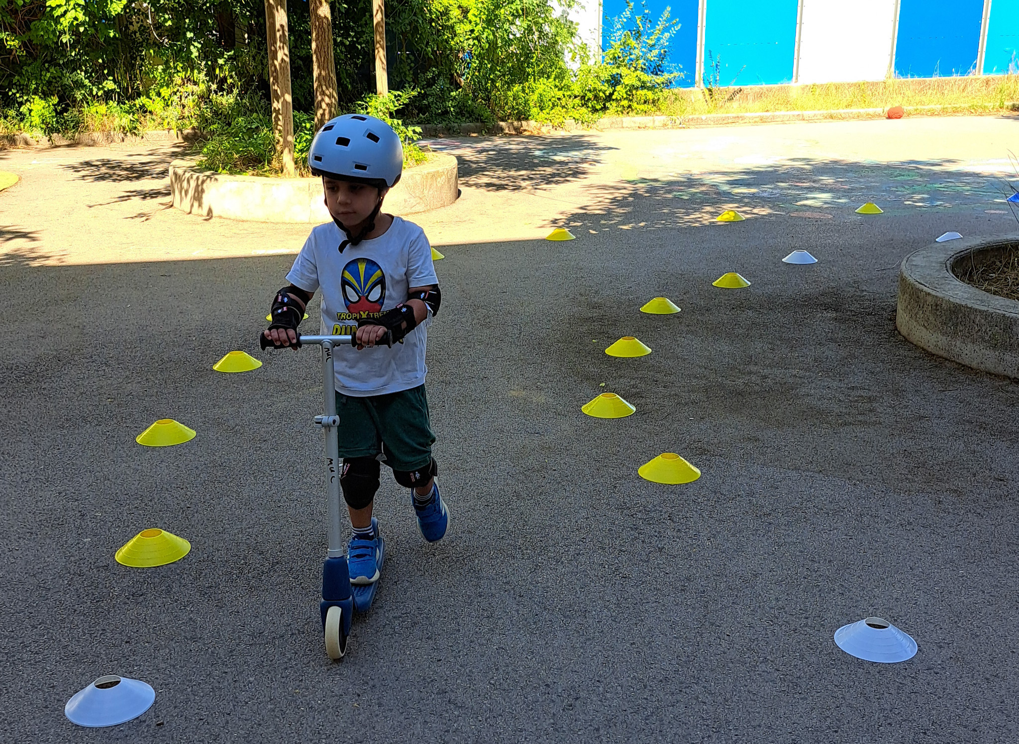 Enfant en trottinette avec casque.