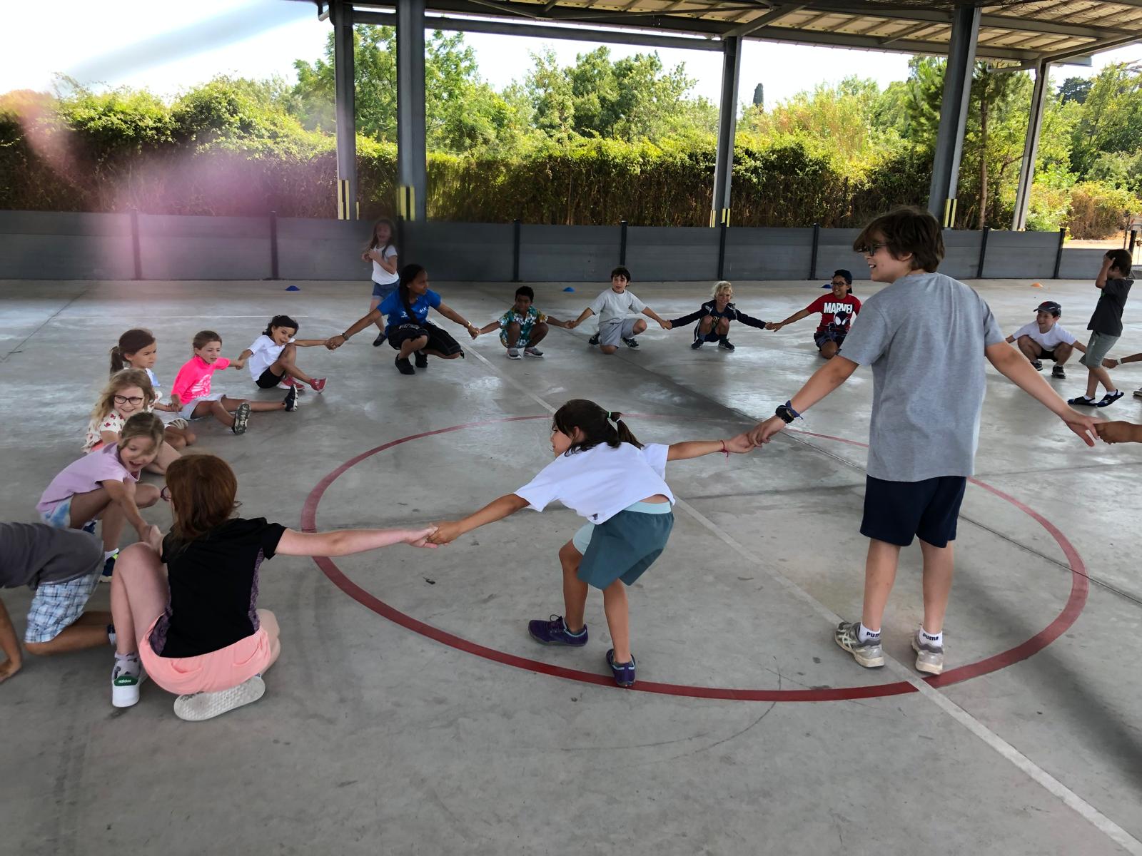 Enfants jouant en cercle à l'extérieur.