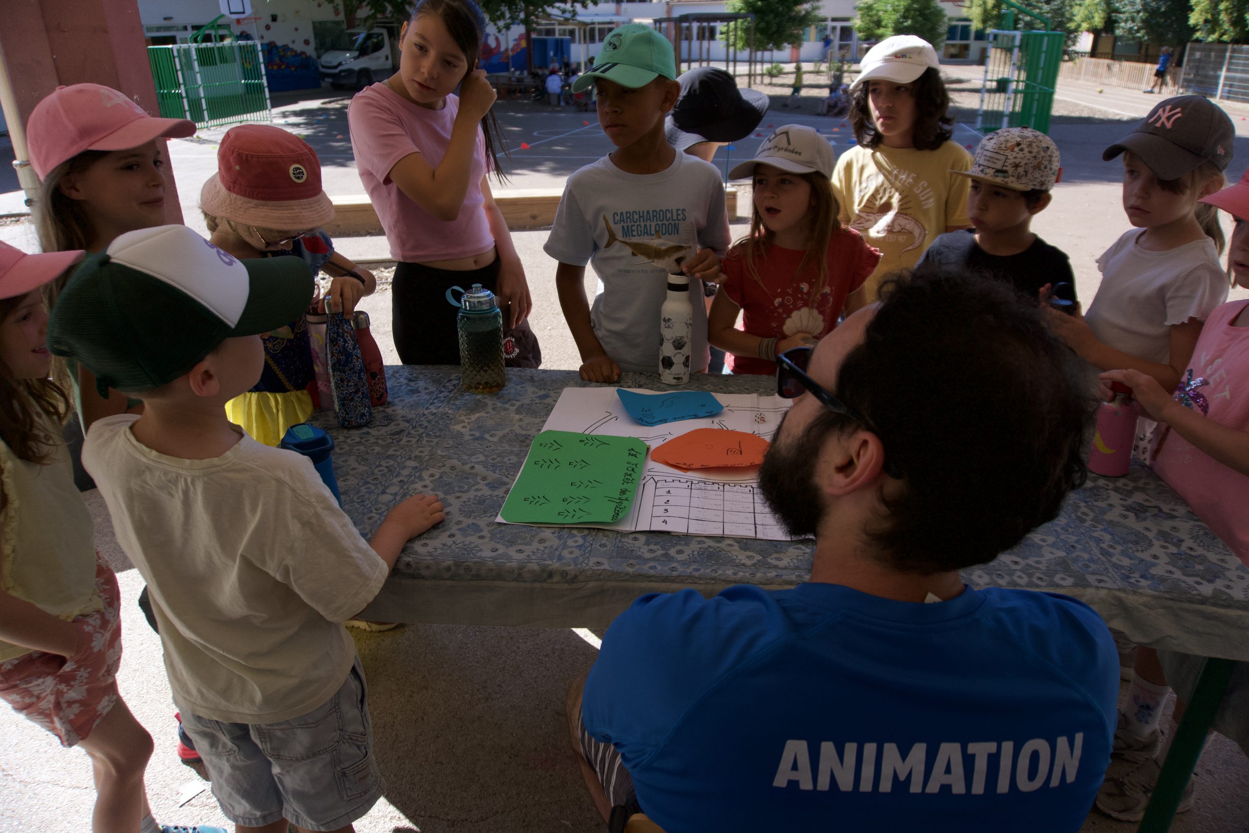 Enfants autour d'une table avec animateur.