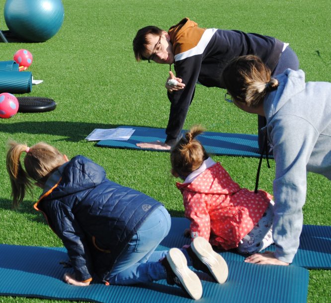 Photo d'une famille qui fait du yoga