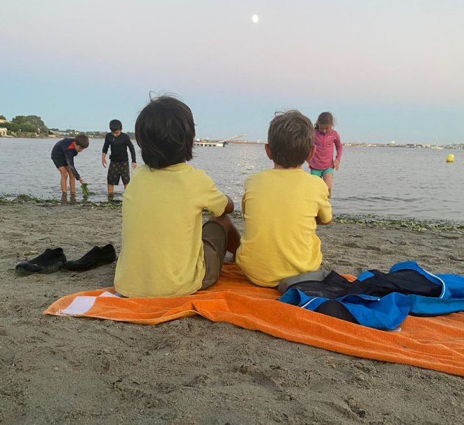 deux enfants assis dans le sable sur la plage